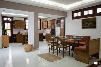 a kitchen and living room with a table and chairs at The BIG one!! in Rhodes Town