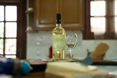 a bottle of wine sitting on a table with a wine glass at The BIG one!! in Rhodes Town