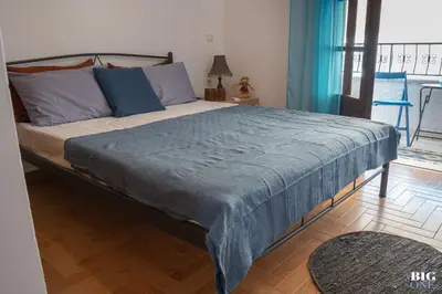 a bedroom with a large bed with a blue blanket at The BIG one!! in Rhodes Town