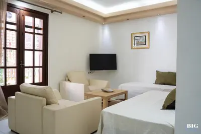 a white room with two beds and a tv at The BIG one!! in Rhodes Town