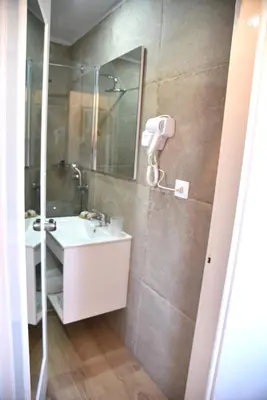a bathroom with a sink and a mirror at Boutique Hotel Tilos Mare in Livadia