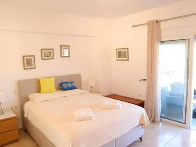 a bedroom with a bed and a sliding glass door at Summer Lovin in Haraki