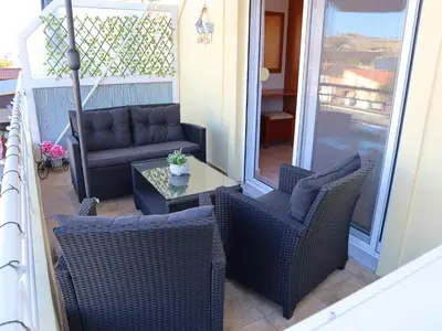 a porch with chairs and a couch and a table at Summer Lovin in Haraki