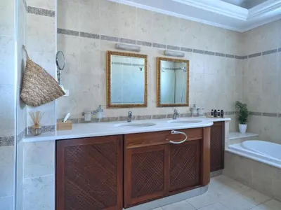 a bathroom with a sink and a tub and a mirror at Chrissiida Villa in Ialyssos