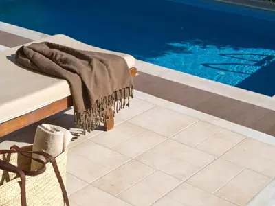 a blanket on a bench next to a swimming pool at Chrissiida Villa in Ialyssos