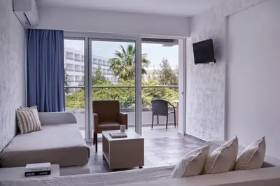 a living room with a couch and a large window at The Apartments by Esperia in Rhodes Town