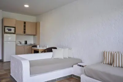 a bedroom with a white bed and a couch at The Apartments by Esperia in Rhodes Town