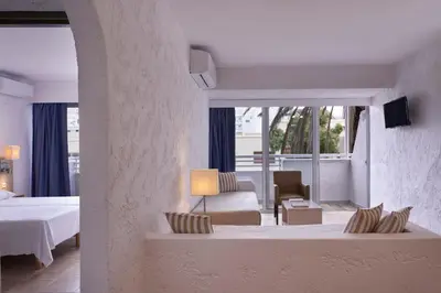 a hotel room with a bed and a living room at The Apartments by Esperia in Rhodes Town