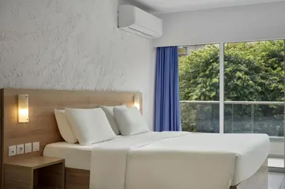 a bedroom with a large white bed and a window at The Apartments by Esperia in Rhodes Town