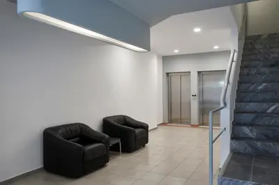 a waiting room with two chairs and a staircase at The Apartments by Esperia in Rhodes Town