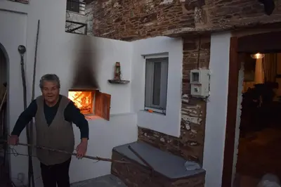 a man holding a rope in a room with a fireplace at Mannashouse in Émbonas