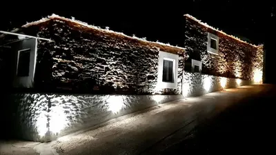 a building with lights on the side of it at night at Mannashouse in Émbonas