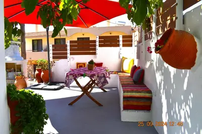 a patio with a table and a red umbrella at Mannashouse in Émbonas