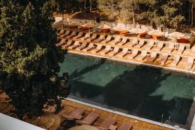 an overhead view of a swimming pool with chairs and umbrellas at Cook's Club Ialysos Rhodes in Ialyssos