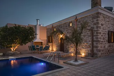 a house with a swimming pool in front of a building at Villa Anaflo in Haraki