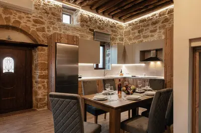 a kitchen and dining room with a table and chairs at Villa Anaflo in Haraki