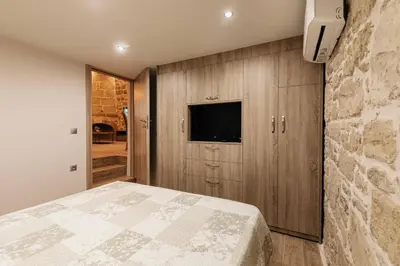 a bedroom with a bed and a tv on a wall at Villa Anaflo in Haraki