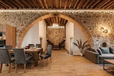 a living room with an archway and a table and chairs at Villa Anaflo in Haraki