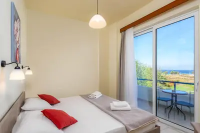 a bedroom with a bed and a view of the ocean at Litsas Studios in Phanaes