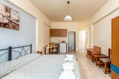 a bedroom with a bed and a kitchen at Litsas Studios in Phanaes
