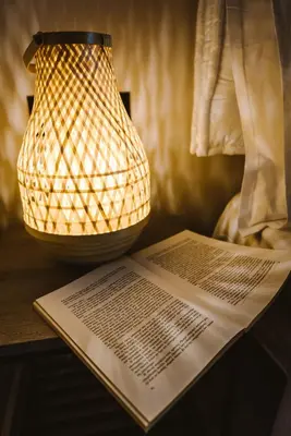 a lamp sitting on a table with a book at Manolis Loft Apartment, Rhodes Town in Rhodes Town