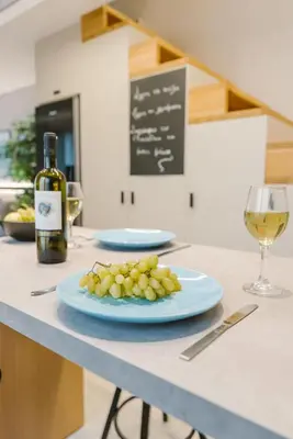 a plate of grapes on a counter with a bottle of wine at Manolis Loft Apartment, Rhodes Town in Rhodes Town