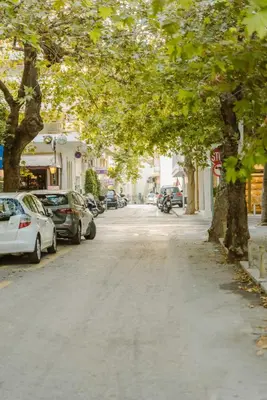 a tree lined street with cars parked on the street at Manolis Loft Apartment, Rhodes Town in Rhodes Town