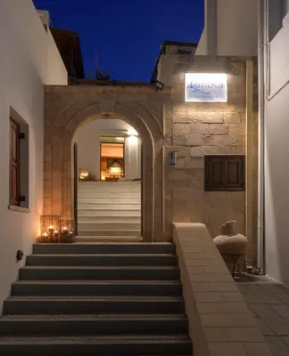 an entrance to a building with stairs at night at Panthea Valasia Boutique Villa in Líndos