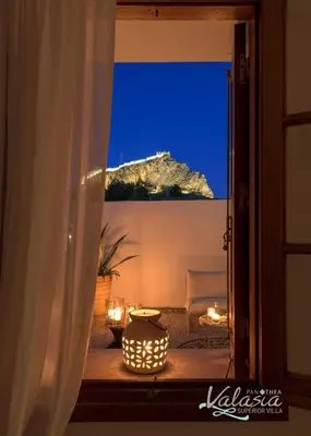 a room with a view of a mountain through a window at Panthea Valasia Boutique Villa in Líndos