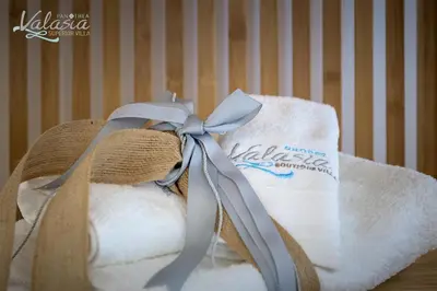 a towel with a ribbon on top of it at Panthea Valasia Boutique Villa in Líndos