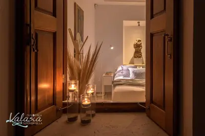 a room with a bedroom with a bed and candles at Panthea Valasia Boutique Villa in Líndos