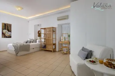 a white living room with a bed and a couch at Panthea Valasia Boutique Villa in Líndos