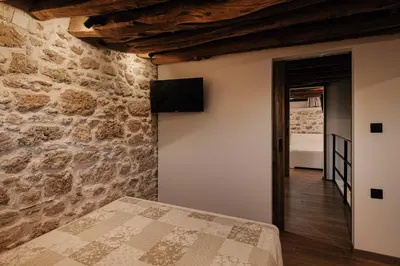 a bedroom with a stone wall and a bed at La casa dell'arch in Haraki