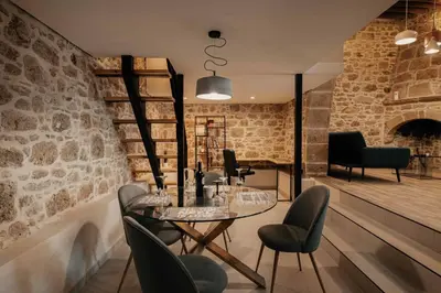 a room with a table and chairs and a brick wall at La casa dell'arch in Haraki