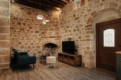 a living room with a tv and a brick wall at La casa dell'arch in Haraki