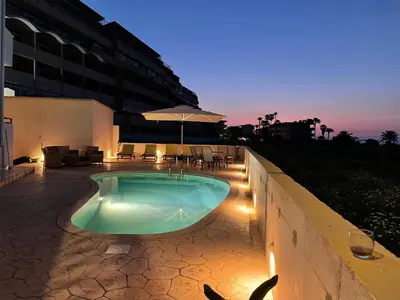 a swimming pool with lights and a building at White&Blue Beachfront Luxury Suite in Ialyssos