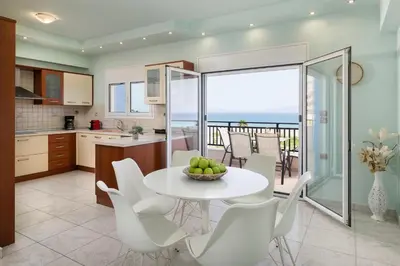 a kitchen and dining room with a table and chairs at White&Blue Beachfront Luxury Suite in Ialyssos