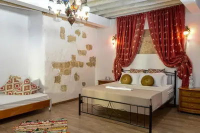 a bedroom with two beds with red curtains at Fatma Hanoum boutique hotel in Rhodes Town