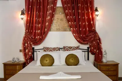 a bedroom with a bed with red curtains at Fatma Hanoum boutique hotel in Rhodes Town