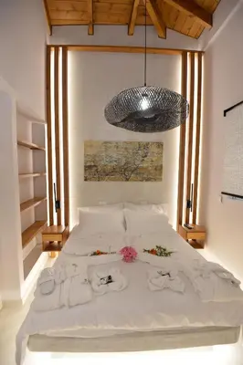 a bedroom with a bed with towels and a chandelier at Kameiros Treasure Villa in Kalavárda