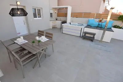 a kitchen and living room with a table and chairs at Kameiros Treasure Villa in Kalavárda