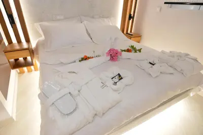 a white bed with white towels and flowers on it at Kameiros Treasure Villa in Kalavárda