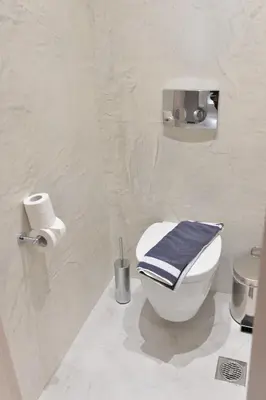 a bathroom with a toilet with a blue towel on it at Kameiros Treasure Villa in Kalavárda