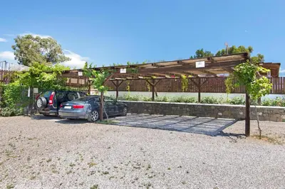 two cars parked in a parking lot under a pergola at Holiday home in Kiotari near the beach in Kiotari