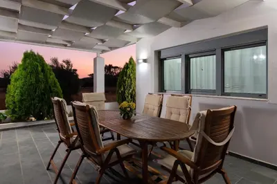 a dining room with a wooden table and chairs at Dama Dama Villas in Gennadi