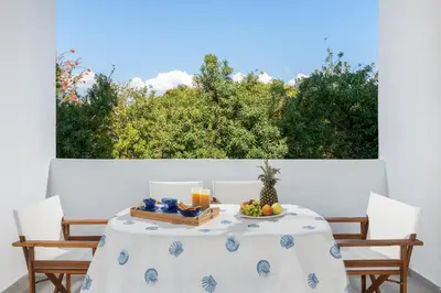 a table with a bowl of fruit and candles on it at Dama Dama Villas in Gennadi