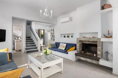 a living room with a blue couch and a fireplace at Dama Dama Villas in Gennadi
