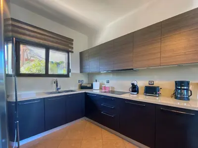 a kitchen with dark blue cabinets and a window at Rosalia House in Rhodes Town