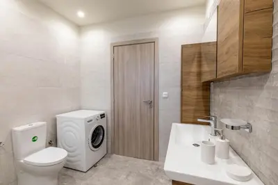 a bathroom with a washer and a toilet and a sink at Ktima Kritikos in Paradeísion
