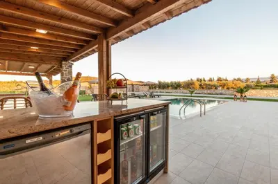 an outdoor kitchen with a view of a pool at Ktima Kritikos in Paradeísion